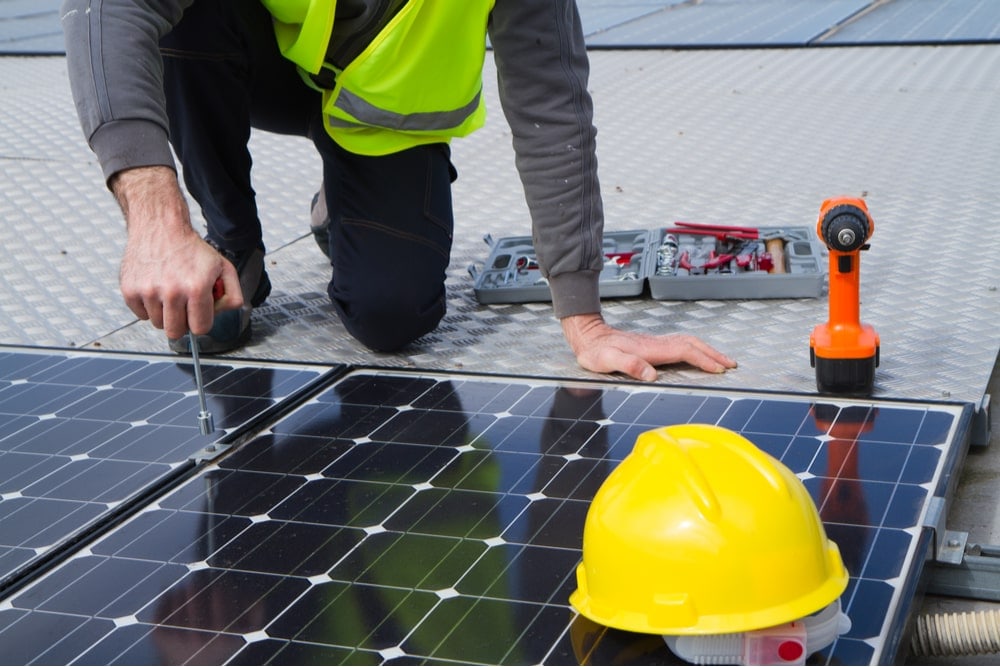 Homem instalando placa solar.